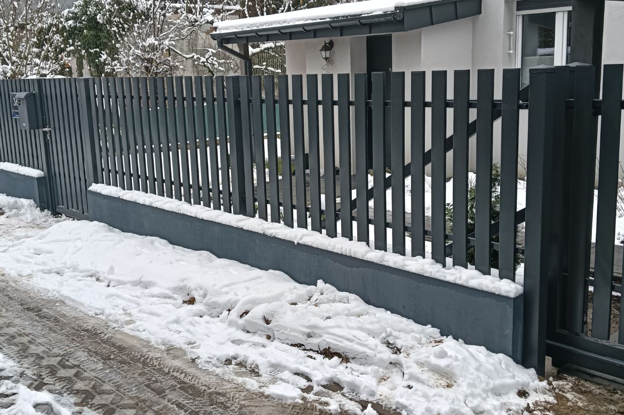 ogrodzenie pionowe na podmurówce zimą