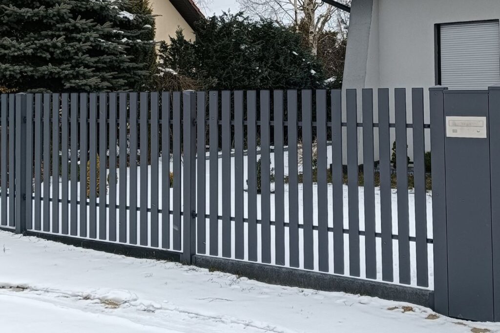 ogrodzenie pionowe metalowe przy posesji zimą