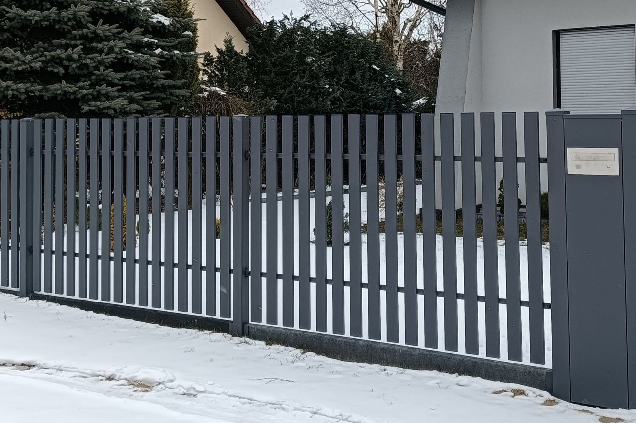 ogrodzenie pionowe metalowe przy posesji zimą